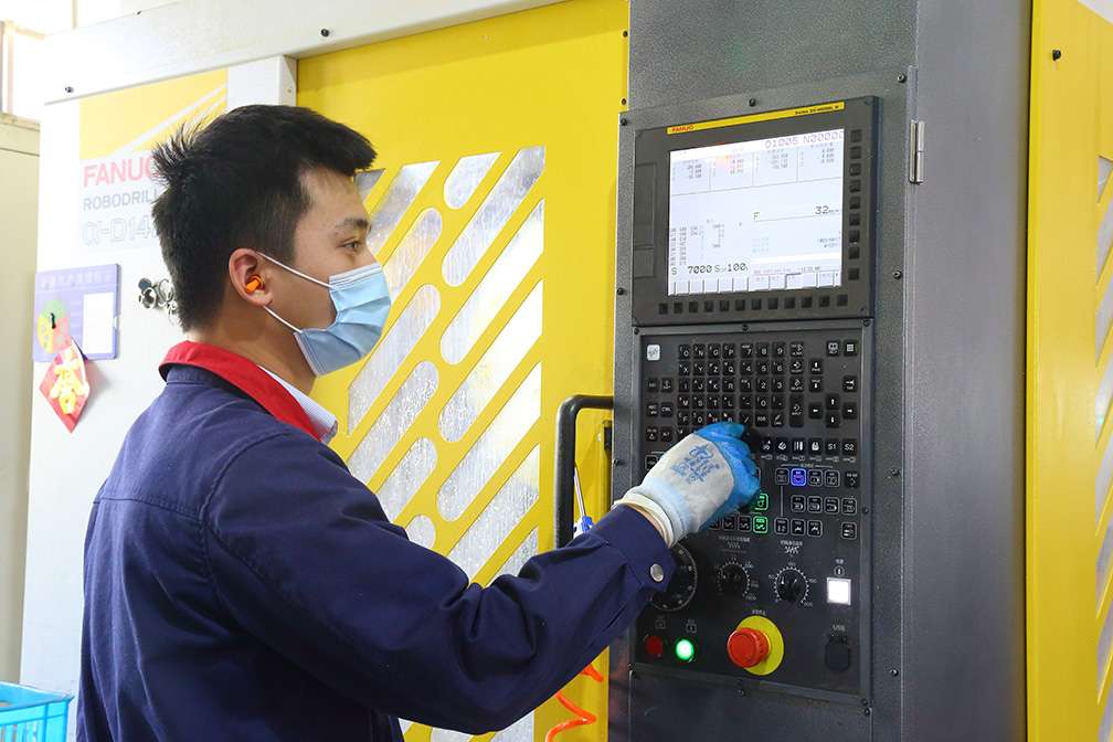 Bepto Pneumatic CNC operator reviewing machining controls for pneumatic component production
