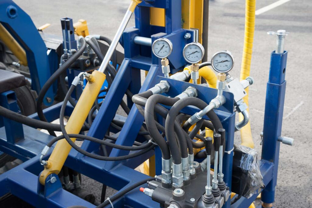 Industrial hydraulic power circuit with cylinders, flexible hoses, control valves, and pressure gauges